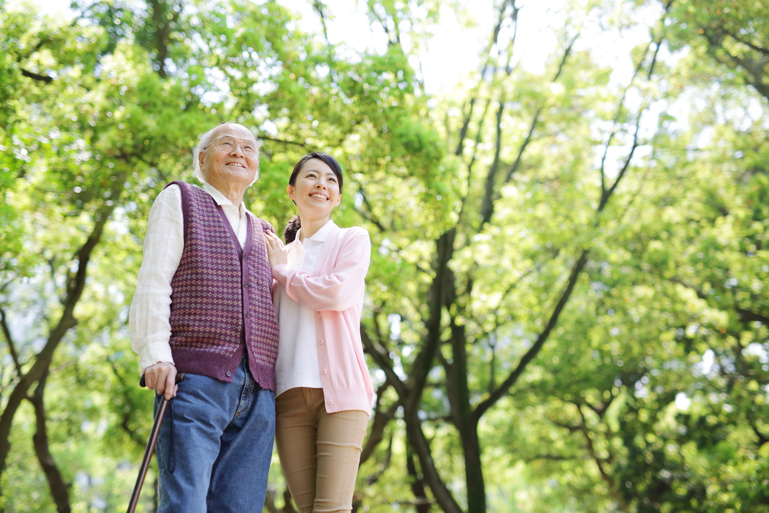 笑顔の高齢の男性と笑顔でサポートする女性の写真